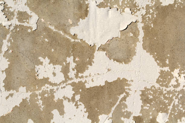 istock Close-up of a weathered concrete wall with peeling white paint abstract textured background 2182012508