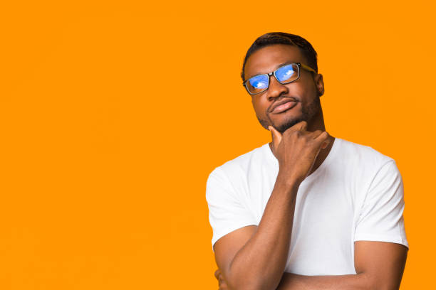 istock African American Guy Thinking Touching Chin Standing Over Orange Background 2182023832