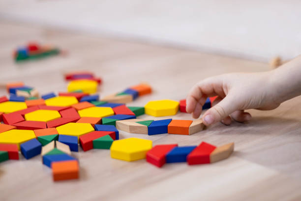 istock A child plays with geometric shapes and makes a colorful circular mandala pattern from a mosaic. 2182029402