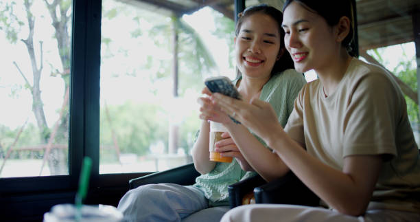 istock Two asian women are enjoy watching something on a mobile phone screen. 2182030972