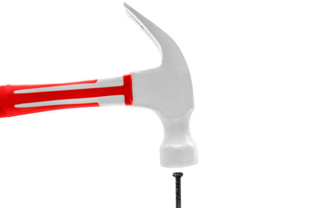 Closeup view of hammer hits a nail isolated over white background. Construction and carpentry concept