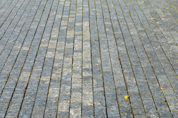 Stone pavement in the rays of the setting sun. Backround of Block pavement on sunset. Texture