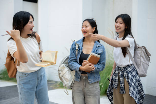 istock A group of cheerful Asian college students enjoying a conversation while walking in their college. 2182037689