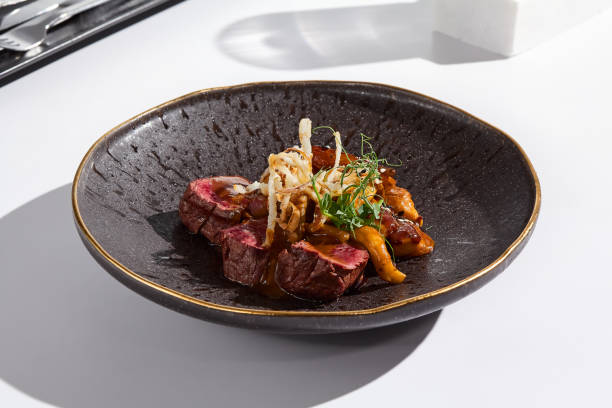 istock Exquisite Beef Tenderloin with Mushroom Sauce on Dark Ceramic Plate in Minimalist Setting 2182039843
