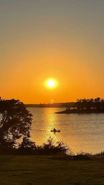 istock Sunset on a lake with a canoe 2182041060