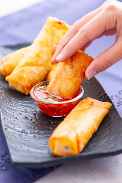 istock Hand Dipping Spring Roll into Sweet Chili Sauce 2182041853