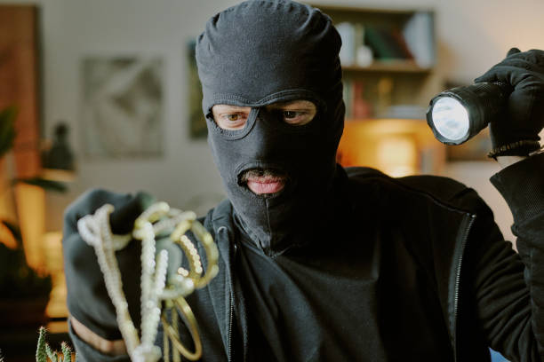 istock Thief in Balaclava Holding Sparkling Jewelry 2182042438