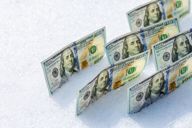 istock us dollar banknotes standing on their side on the snow surface at sunny winter day 2182045800