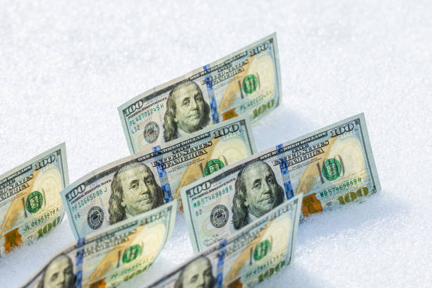 istock us dollar banknotes standing on their side on the snow surface at sunny winter day 2182045852