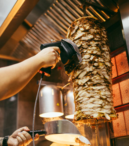 A chef expertly slices a rotating gyro skewer at the restaurant
