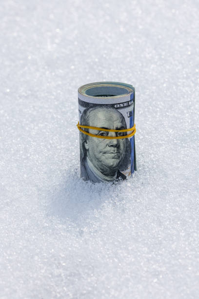 istock Roll of us dollar banknotes on the snow surface 2182045905
