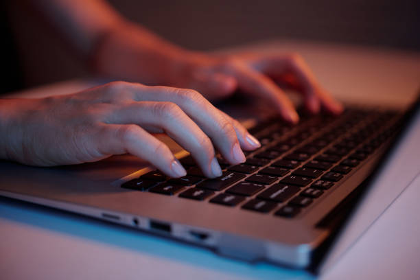 istock Hands Typing on Laptop Keyboard in Dim Light 2182046402