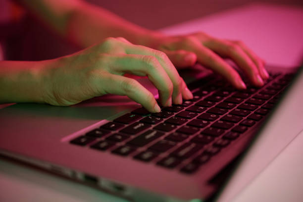 istock Hands Typing on Laptop Keyboard Under Colorful Light 2182046446