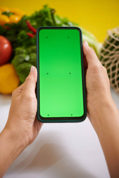 istock Holding Smartphone with Green Screen for Mockup Display 2182046619