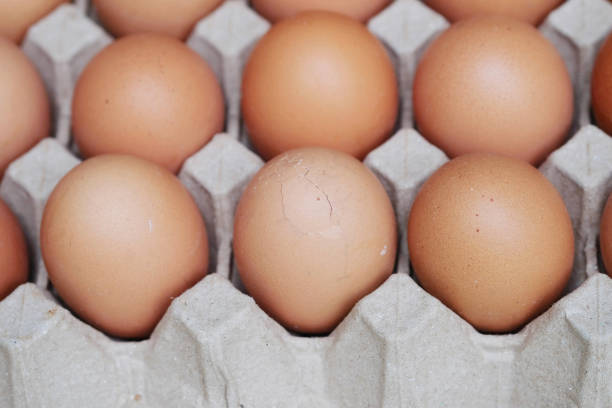 Fresh eggs in a brown paper egg tray. Some eggs had cracked shells.