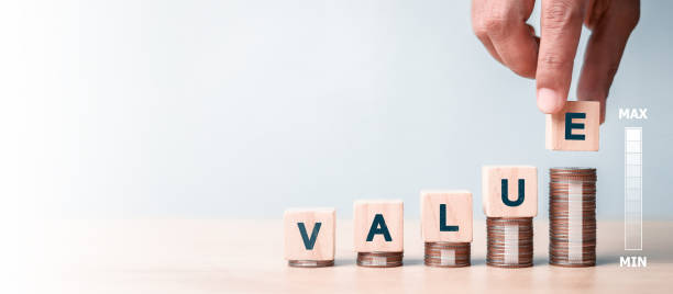 Value concept. VALUE wording on increasing wooden block on coins stacking. stock photo
