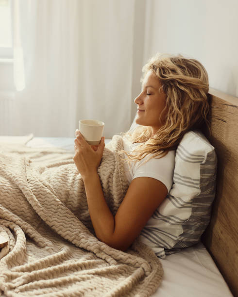 istock Smiling woman relaxing during coffee time in bed. 2182047911