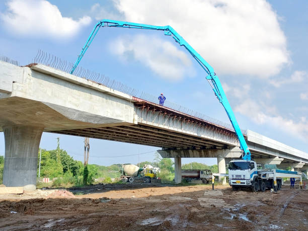 istock concrete pump truck with worker working on elevated road  construction site 2182047940