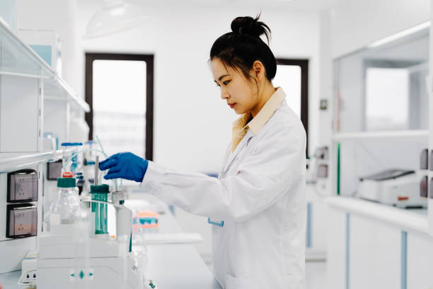 istock Science Research Laboratory: Chinese female scientist working with digital tablet in modern laboratory. 2182052465