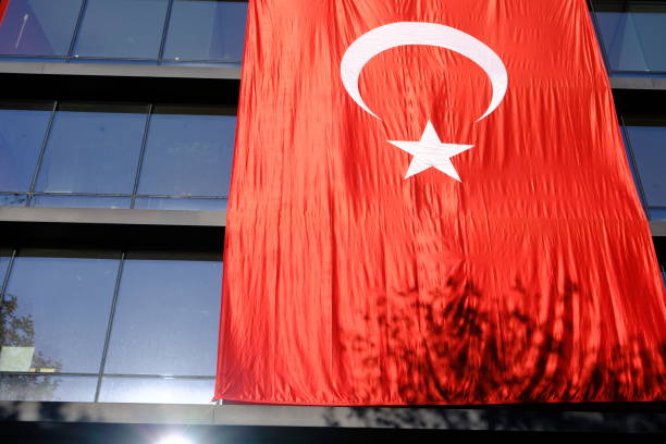 Turkish Flag with red crescent and star hanging on a building.