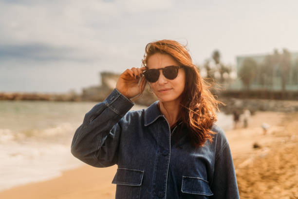 istock Woman at the beach looking at camera 2182054868