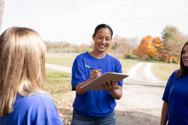 istock Advisor attends charity volunteer drive sign ups with diverse clients 2182054900