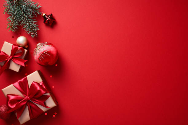 istock Christmas card. Flat lay gold gift boxes with red ribbon bows on red background. 2182057020