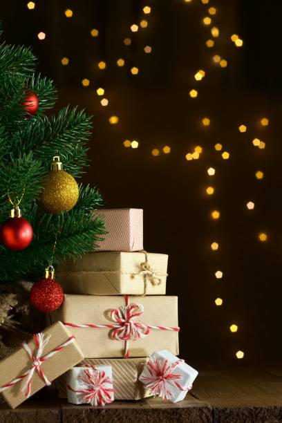 istock Gift boxes under decorated Christmas tree. Glowing  lights in the background. Space for text 2182057561