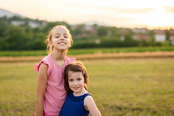Portrait of two happy sisters hugging in nature