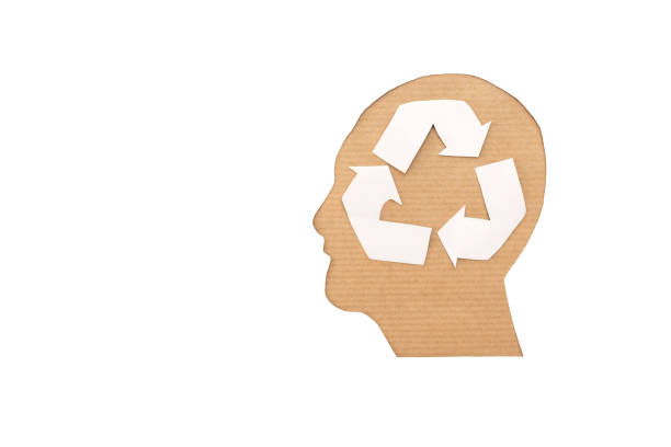 istock Recycle Symbol in Human Head Silhouette on cardboard and white background 2182058350