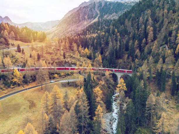 istock Red Train Winding Through Autumnal Mountain Scenery 2182063112