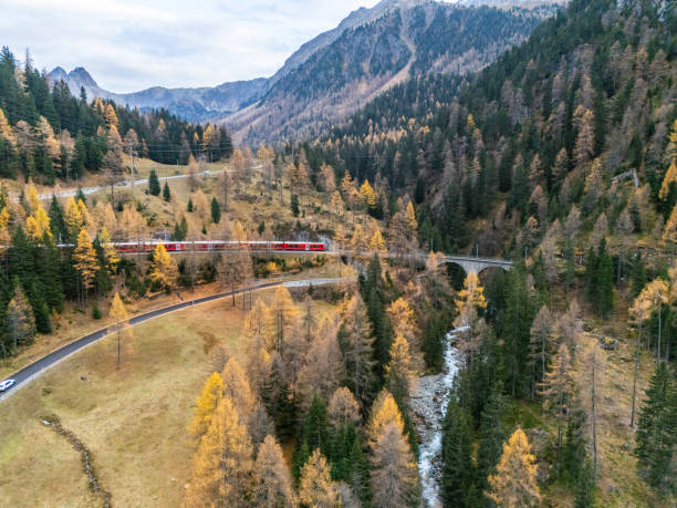 istock Red Train Winding Through Autumnal Mountain Scenery 2182063113