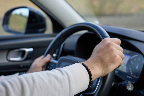 istock the man is driving car, hand detail 2182063522