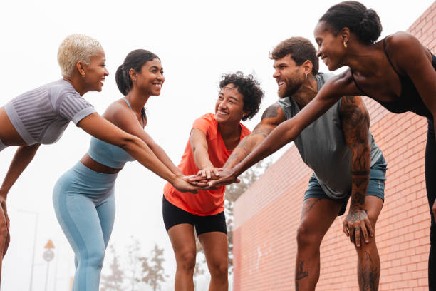 istock Happy athletes joining hands before training in the city 2182064731