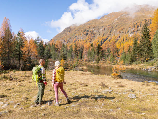 istock Hikers Enjoying Scenic Autumn Landscape by Mountain Stream 2182065691