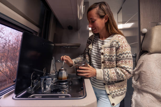 istock Woman Prepares Coffee Inside Camper on a Cozy Autumn Day 2182067546