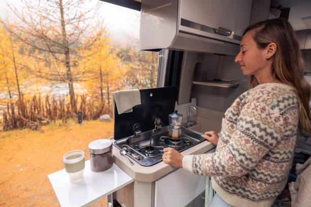 istock Woman Brewing Coffee in Cozy Camper Van with Autumn View 2182067626