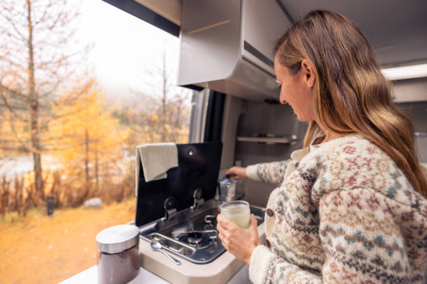 istock Woman Enjoying Coffee Preparation in Cozy Camper Van 2182067708