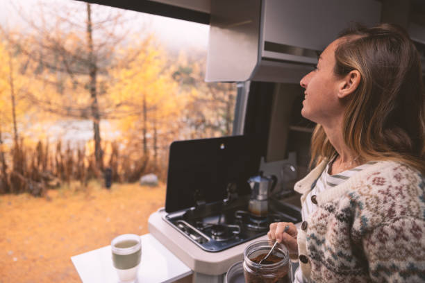 istock Woman Prepares Coffee in Camper Van with Autumn View 2182067839