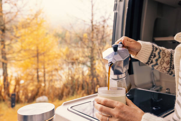 Pouring Fresh Coffee in Camper Van with Autumn View