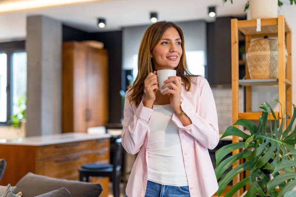 istock Woman sipping hot drink while relaxing at home. 2182068515