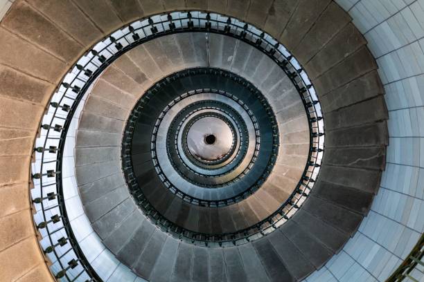 istock Mesmerizing spiral staircase winds its way upwards, creating a hypnotic pattern of light and shadow 2182070244