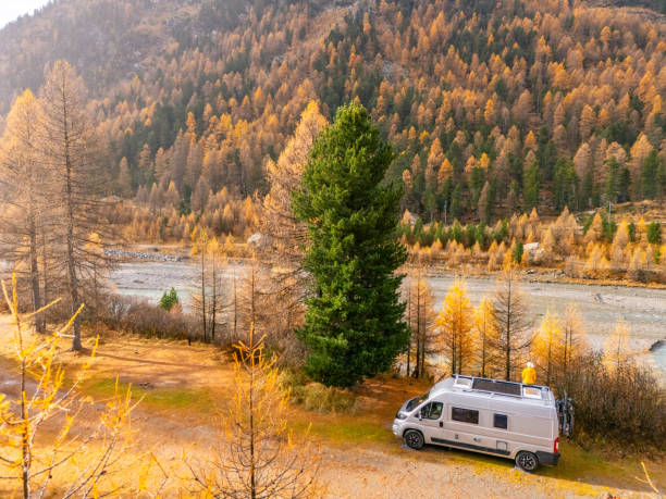 istock Adventurer on Campervan Roof Overlooking Autumn Forest 2182070872