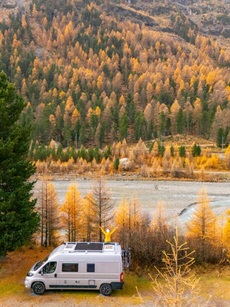 istock Adventurer on Campervan Roof Overlooking Autumn Forest 2182070883