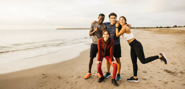 istock Happy friends enjoying a joyful morning workout on beach 2182071340