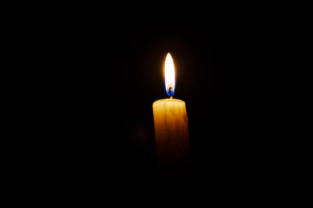 istock Close-up single candle burning on dark black background 2182072892