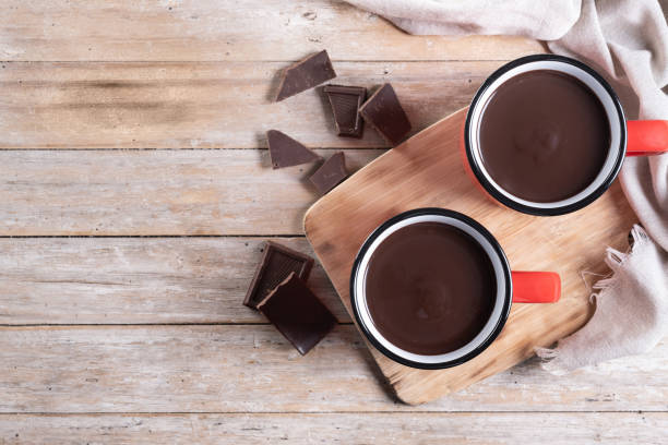 istock Hot chocolate drink in red mug on wooden table 2182074068