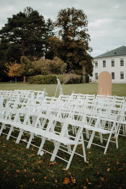 istock Outdoor wedding setup with white chairs on lawn. 2182075458