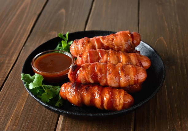 istock Bacon wrapped sausages with barbecue sauce 2182078122
