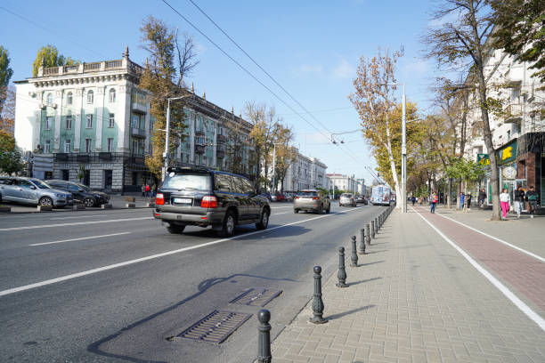 Traffic negotiating the roundabout in Roman Square, Piata Romana, in central Bucharest, Romania. There are advertisements including CocaCola, McDonalds and Betano betting site.